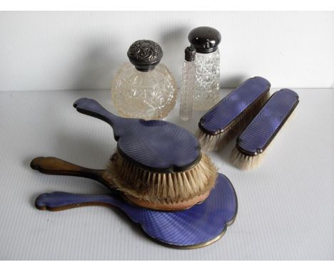 Three silver-topped vanity table bottles, a five-piece brass and enamel brush set and a selection of silver plated tableware,