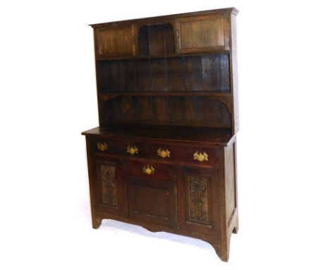 A Victorian oak dresser, the plate rack with a central recess flanked by cupboard doors, over a shelf, the base with two long