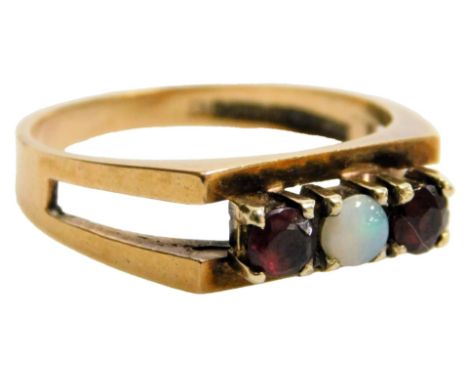 A 9ct rose gold garnet and opal three stone ring, in a high claw setting, size O/P, 3.2g.