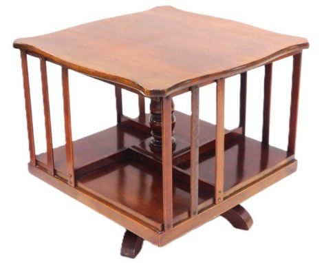 An Edwardian mahogany table top revolving bookcase, of square section, with a serpentine top, having four shelf sections, rai