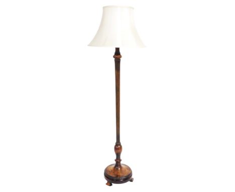 A Victorian mahogany standard lamp, with a turned and fluted column, raised on a circular base, and three shaped feet, with c