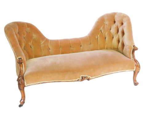 A Victorian mahogany conversation sofa, upholstered in gold button back draylon, raised on foliate carved cabriole legs, on c