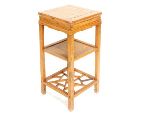 An early 20thC Chinese hardwood urn stand, of square section, with a three planked shelf, and carved under tier, 78cm high, 3