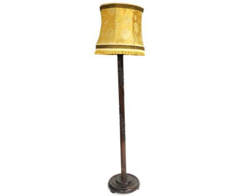A early 20thC Chinese hardwood standard lamp, with dragon carving, raised on a circular base, with shade, 194cm high.
