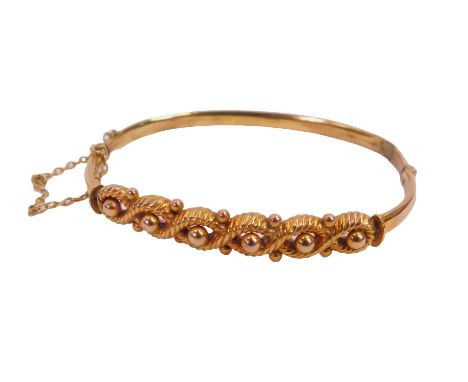 An Edwardian yellow metal hinged bangle, with rope and ball design, 5.6g boxed (AF).
