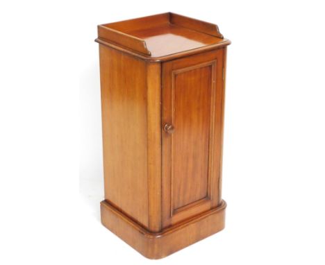 A Victorian mahogany pot cupboard, with a three sided, galleried top, above a panelled door enclosing a single shelf, raised 