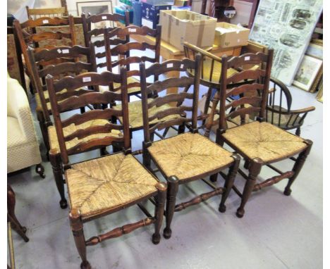 Harlequin set of seven oak ladder back dining chairs with rush seats and turned supports 