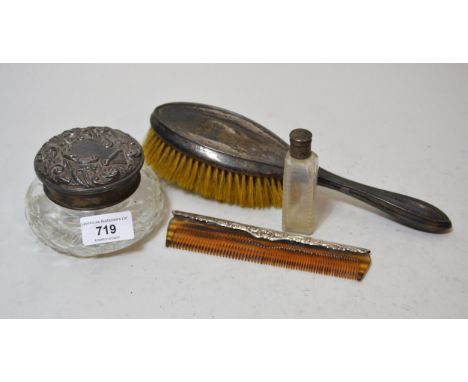 Silver topped dressing table jar with embossed cover, silver backed brush and comb and a cut glass perfume bottle 