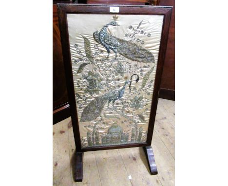 Early 20th Century oak firescreen inset with an Indian silk, metal thread and sequin picture of peacocks and flowers, 78cms x