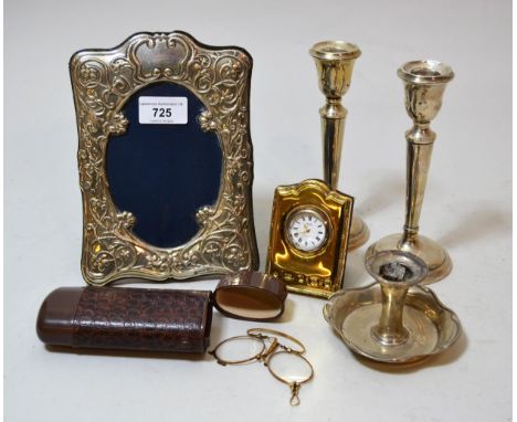 Silver embossed photograph frame, silver gilt miniature clock, pair of silver candlesticks and a silver taper stick and a pai