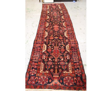 Sarouk runner with a multiple vase and floral design on a dark blue ground with borders, 391 x 110cms (some moth damage) 