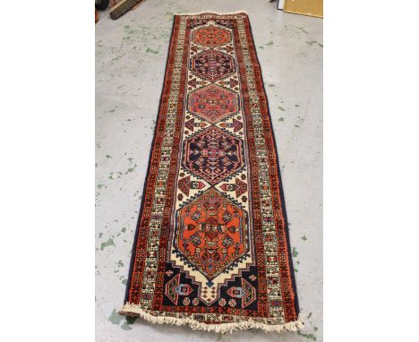 Indo Persian runner with five medallion design on an ivory ground with borders, 300cms x 70cms approximately 