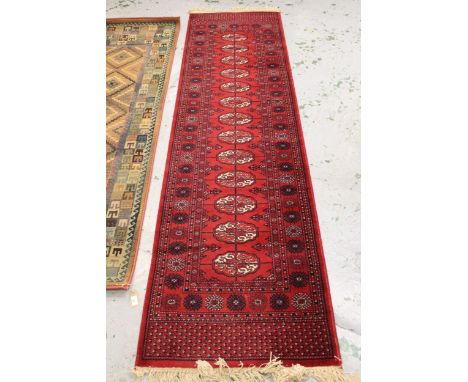 Machine woven runner of Turkoman design, 2.7m x 70cms approximately, together with a similar, smaller runner 