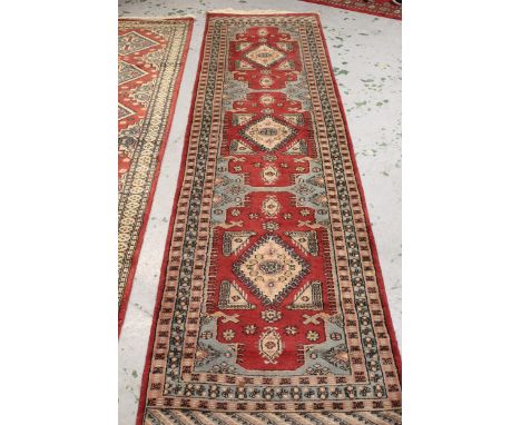 Indo Persian runner with a triple hooked medallion design in shades of claret and blue, 3m x 80cms approximately, together wi