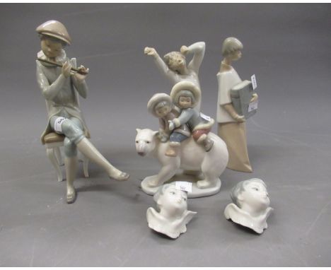 Lladro figure of a seated boy playing a flute, 25cms high, another of two children riding a polar bear, two small Lladro cher