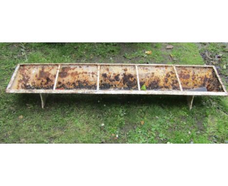 A vintage cast iron pig feeding trough of rectangular form with four rung divisions and weathered painted finish, 5ft long