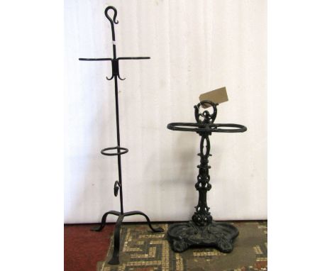 A reproduction cast iron two divisional umbrella stand with foliate detail, together with a further ironwork stand, with trip