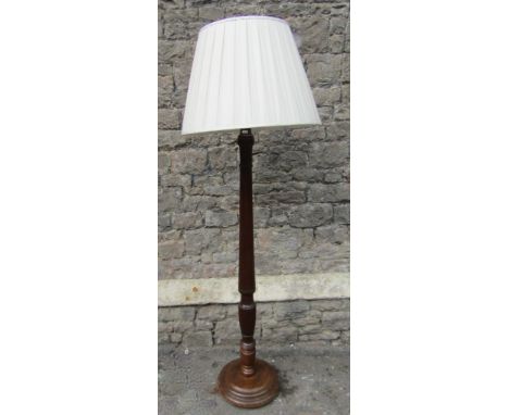 A Georgian style walnut standard lamp, with partially reeded stem and stepped disk shaped platform base, complete with shade