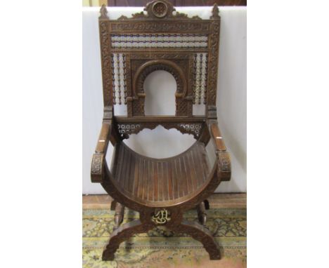 A 19th century Moorish elbow chair, the carved framework with repeating geometric detail, enclosing further bead work and ivo