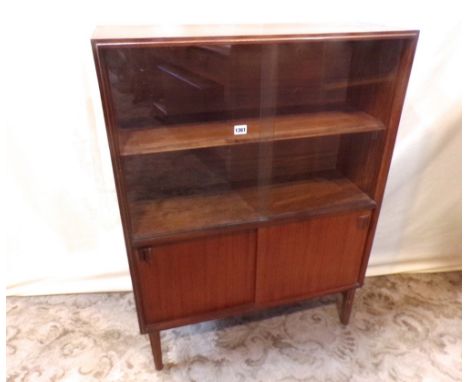 A low teak veneered side cabinet enclosed by four sliding the doors, the upper glazed revealing a single adjustable shelf wit