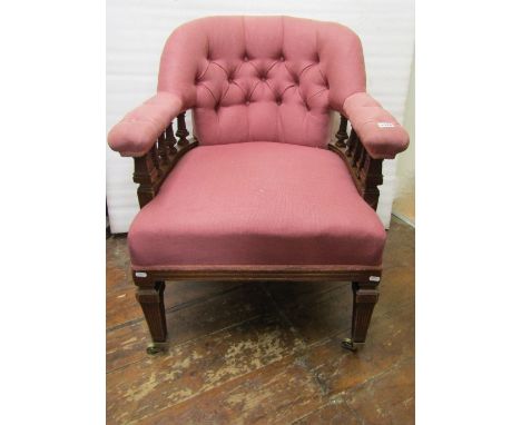 A late Edwardian tub chair with upholstered seat and arched button back, raised on square cut and reeded supports with brass 