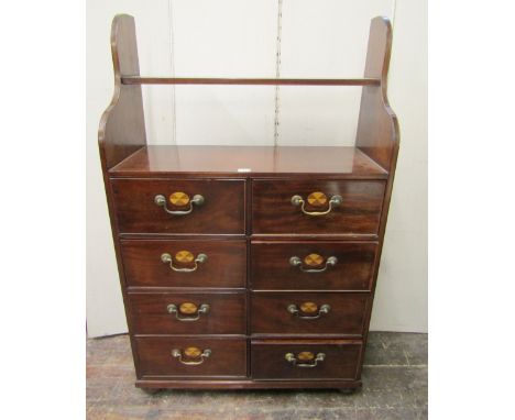 An unusual mahogany chest fitted with a side by side arrangement of eight drawers, with oval inlaid panels, beneath an open s