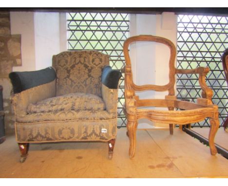 A pair of Victorian nursing or low drawing room chairs with upholstered seats and button backs within showwood frames on scro