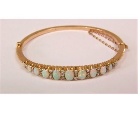 Edwardian opal and diamond bangle set with eleven graduated oval opals interspersed with diamonds, largest opal 7 x 5mm appro