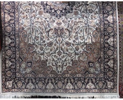 Full pile Persian rug decorated with scrolled navy blue floral decoration upon an ivory ground, 230 x 140cm