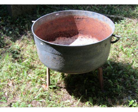 A large 19th century cast iron cauldron, later adapted as a planter and raised on an iron tripod base, 61 cm diameter 
