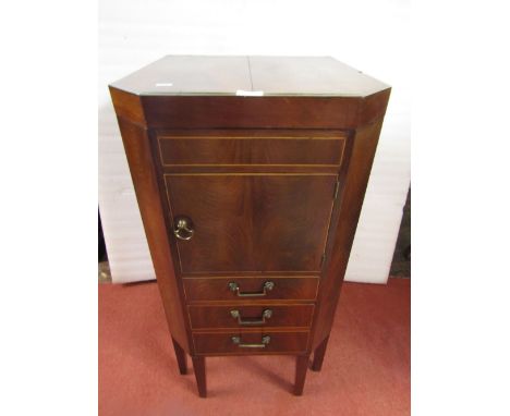 A Georgian mahogany commode with rising lid revealing a segmented interior, two drawers, disguised as three, with brass fitti