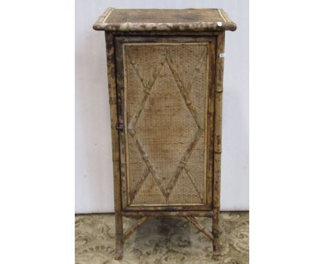 A late Victorian bamboo framed side cupboard enclosed by a rectangular moulded panel door