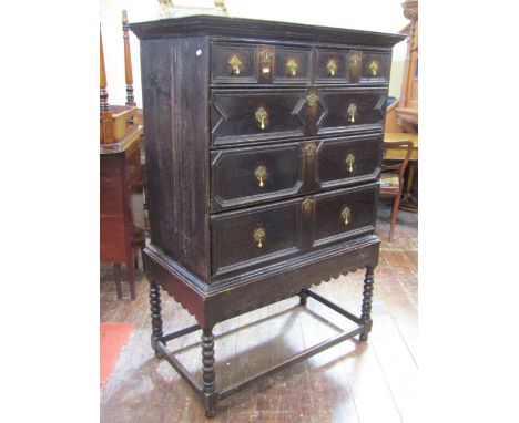 A Jacobean style oak chest on stand, the chest with three long and two short drawers, with applied block moulded detail, the 