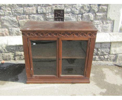 A 19th century oak and glazed side cabinet, with trailing geometric detail, 87cm wide, beneath a raised panel carved, initial