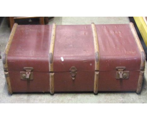 A 19th century domed top trunk, overlaid in oil skin with studded detail and side carrying handles together with a vintage la