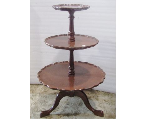 A reproduction Georgian style floorstanding dumb waiter on three graduated circular revolving tiers with pie crust outline ra