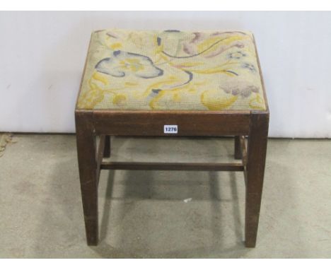 A Georgian style stool of square form with drop in floral tapestry seat raised on four square tapered legs united by a H shap