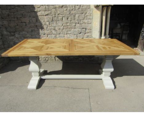 A good quality oak refectory table, the rectangular geometric patterned top raised on a painted base with vase shaped columns