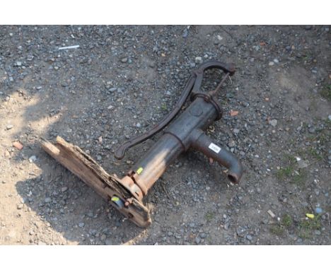 A cast iron manual water pump mounted to wooden board AF
