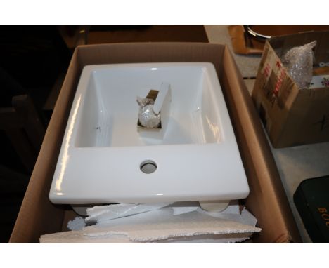 A ceramic wash basin of square form with single mixer tap (unused in original pox)