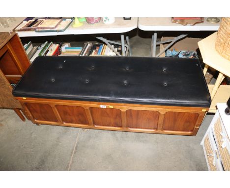 A wooden and button down upholstered ottoman