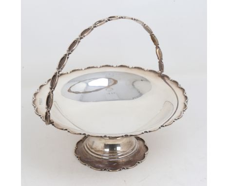 A George V silver swing-handled fruit bowl, circular pedestal form with scalloped rim, by William Hutton & Sons Ltd, hallmark