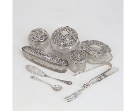 A group of silver-topped dressing table toilet jars, silver sugar tongs, butter knife, mustard spoon and plated pickle forLot