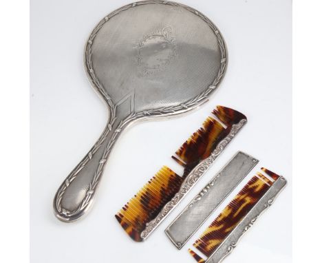 A silver-backed dressing table hand mirror, and 2 silver-mounted combs, mirror length 28cm (3)Lot sold as seen unless specifi