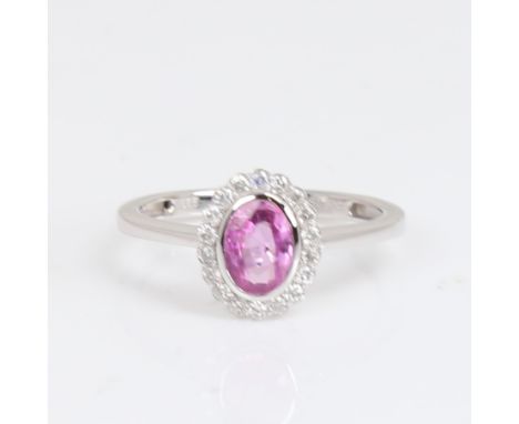 A modern 14ct white gold pink sapphire and diamond cluster ring, set with oval mixed-cut sapphire and modern round brilliant-