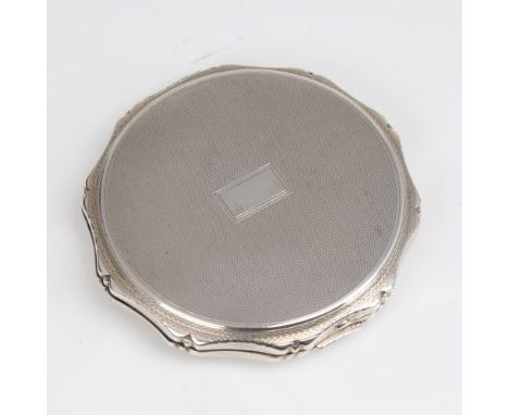 An Elizabeth II circular silver compact, allover engine turned decoration with scalloped rim and gilt interior, by Kigu Ltd, 