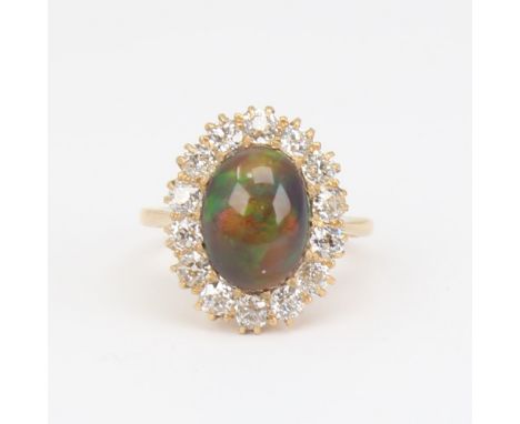 An early 20th century 18ct gold black opal and diamond cluster ring, set with oval high cabochon black opal surrounded by old