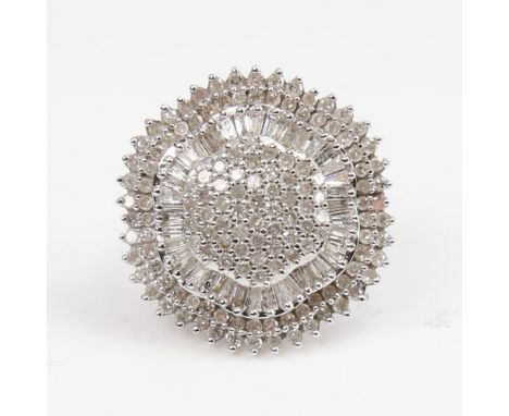 A large 9ct white gold diamond cluster cocktail ring, set with round and tapered baguette-cut diamonds, total diamond content