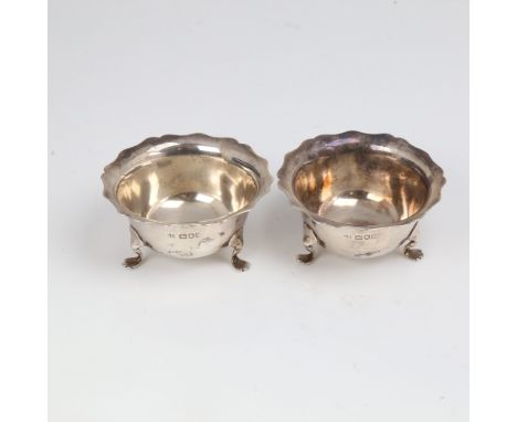 A pair of Edwardian silver salt cellars, circular form with scalloped rim on 3 feet, by Robert Pringle & Sons, hallmarks Lond