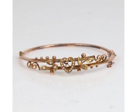 An early 20th century 9ct gold split-pearl heart and floral hinged bangle, hallmarks Chester 1905, setting height 11.9mm, int